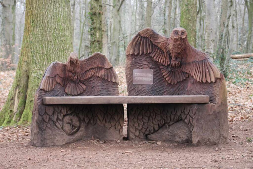 Wooden sculpture of a bench with a bird on each end